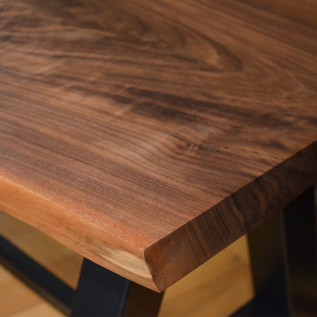 A bench made with live edge walnut lumber used as the seat.
