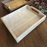 Wooden tray with a handle on a wooden surface made from Curly Maple