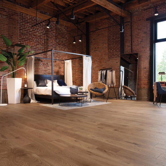 Bedroom furnished with brick walls and Mirage White Oak hardwood flooring.